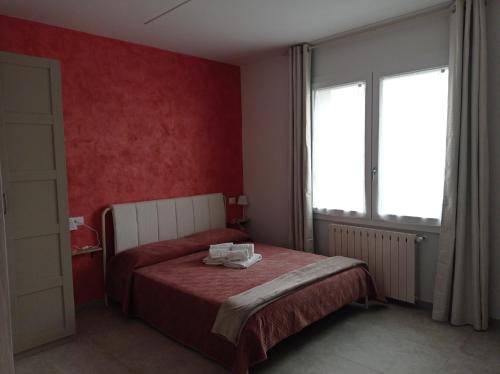 1 dormitorio con cama y pared roja en B&B infinity, en Villanova