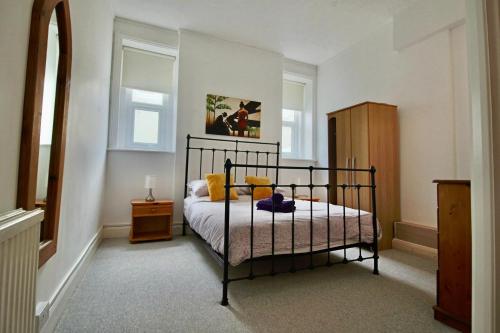 1 dormitorio con cama negra y almohadas amarillas en The Courtyard, 30 Seconds to Sea By Air Premier, en Seaford