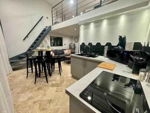 - un salon avec un escalier, une table et des chaises dans l'établissement Saint Remy de Provence: Loft, à Saint-Rémy-de-Provence