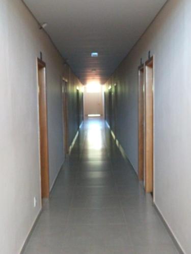 an empty hallway in a building with the light on at Hotel Cabana in Caetanópolis