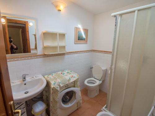 y baño con lavamanos y lavadora. en Villetta Cala Petralana, en Porto Pollo