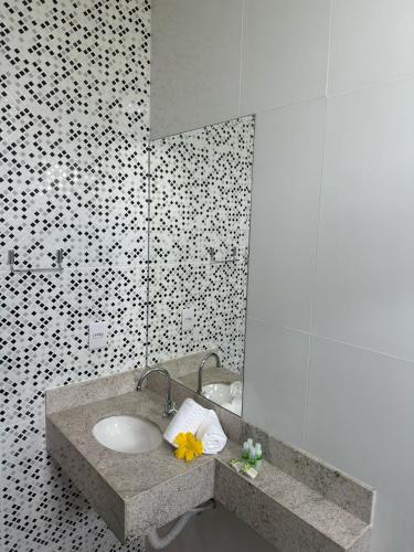 La salle de bains est pourvue d'un lavabo et d'un miroir. dans l'établissement Hotel Cabana, à Caetanópolis