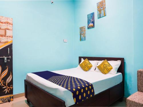 a bedroom with a bed with a blue wall at OYO Hotel Hanu Inn in Bilāspur