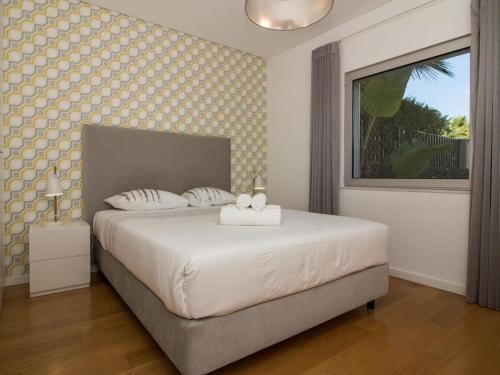 Schlafzimmer mit einem großen weißen Bett und einem Fenster in der Unterkunft Luxury House - Privat Heated Pool & Ecologic & BBQ & Privacy & Albufeira in Albufeira