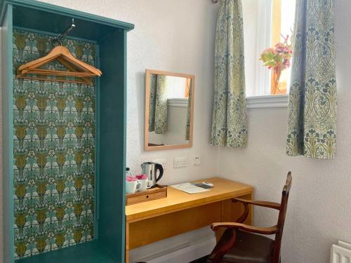 ein Badezimmer mit einem Schreibtisch, einem Spiegel und einem Stuhl in der Unterkunft Ushaw Historic House, Chapels & Gardens in Durham