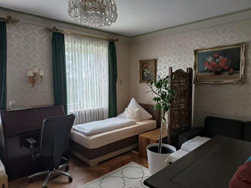 ドナウヴェルトにあるPension Haus Gertrudのベッド1台、椅子、テーブルが備わる客室です。