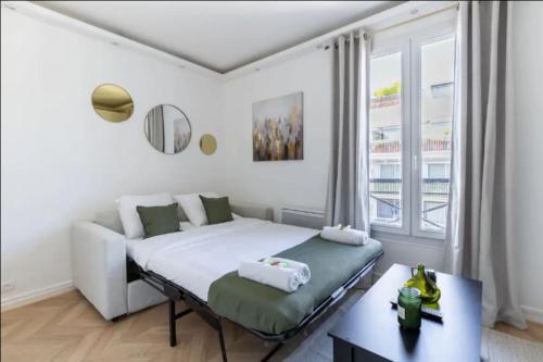 ein weißes Schlafzimmer mit einem Bett und einem Fenster in der Unterkunft So Ouest/Courcelles : Magnifique Studio in Levallois-Perret