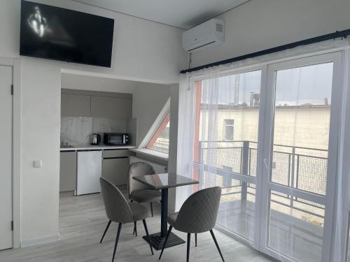 a living room with a table and chairs and a large window at Hotel Femina in Zhytomyr