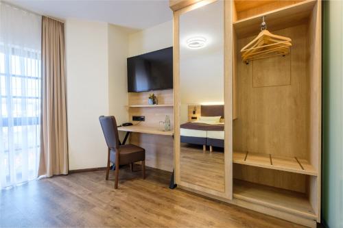 a room with a desk with a chair and a mirror at Landhaus Alte Scheune in Frankfurt/Main