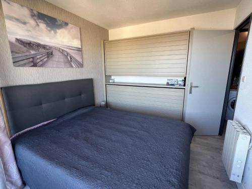 une chambre avec un lit et une porte avec une fenêtre dans l'établissement INDES GALANTES Tres joli T2 vue mer piscine Cap d'Agde, au Cap d'Agde