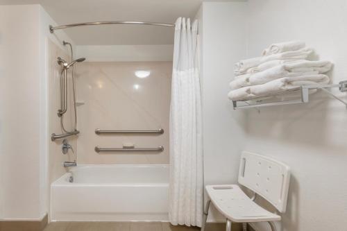 a white bathroom with a tub and a shower at Surf and Sand Fernandina Beach at Amelia Island, an Ascend Collection Hotel in Fernandina Beach