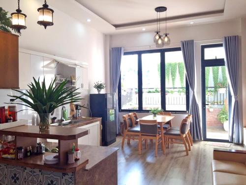 a kitchen and living room with a table and chairs at Nhà Nhi Đà Lạt in Da Lat