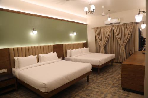 um quarto de hotel com duas camas e uma secretária em Summer House Nandi Foothills em Nandi
