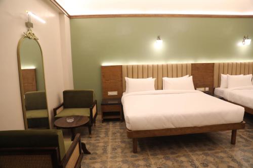 a hotel room with two beds and a chair at Summer House Nandi Foothills in Nandi