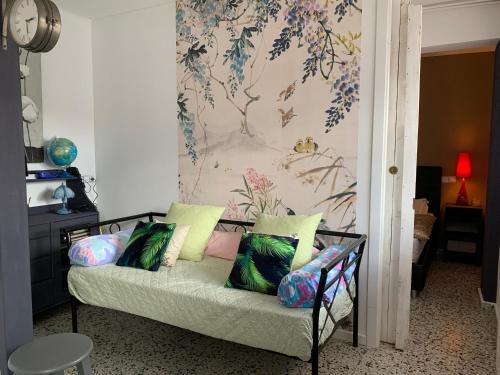 Sofá con almohadas en una habitación con papel pintado en 6 Herriko Etxea Plaza en Bera