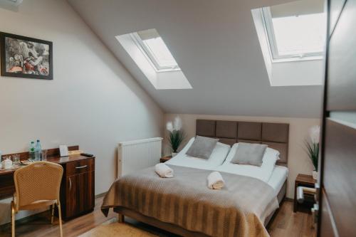 a bedroom with a bed and a desk and windows at De Facto in Zambrów