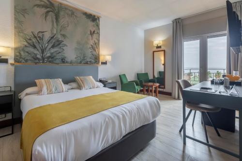 Habitación de hotel con cama grande y escritorio. en Soho Boutique Los Naranjos, en Málaga