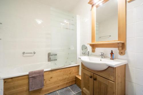 a bathroom with a white sink and a shower at Ecrin des sybelles in La Toussuire