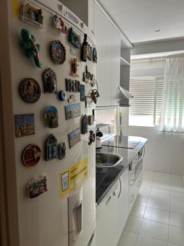 a kitchen with a refrigerator with magnets and a sink at Cómoda Habitación Individual in Madrid
