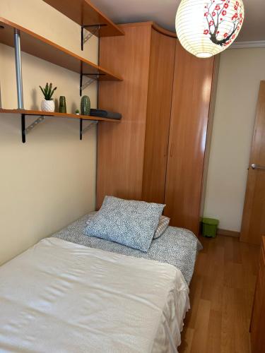 a bedroom with a bed and a wooden cabinet at Cómoda Habitación Individual in Madrid