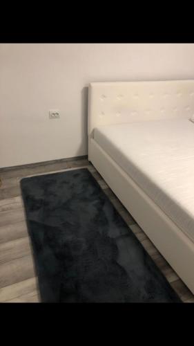 een wit bed in een kamer met een zwart tapijt bij Casa Alex in Dîrlos