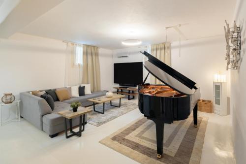 a living room with a piano and a couch at Villa Nausithoe 1 Paros in Logaras