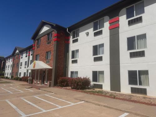 a row of apartment buildings in a parking lot at Super 8 by Wyndham College Station in College Station