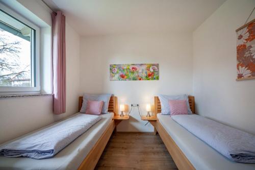 2 Betten in einem Zimmer mit Fenster in der Unterkunft Ferienhaus Steinenberg in Bad Waldsee