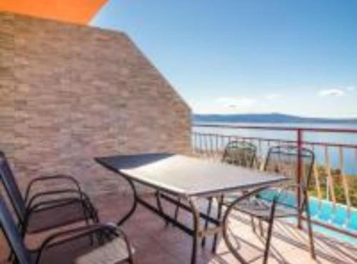 een patio met een tafel en stoelen op een balkon bij Apartments Panorama in Crikvenica