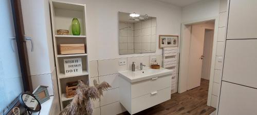 a white bathroom with a sink and a mirror at Gemütliche 3 1/2 Zimmer Wohnung in Ludwigsburg