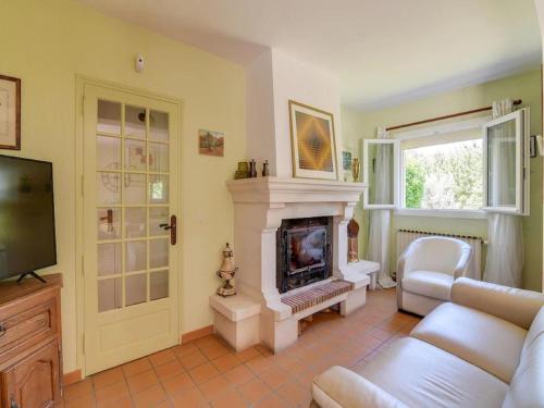 a living room with a fireplace and a tv at Superb house with pool near the Luberon in Oppède