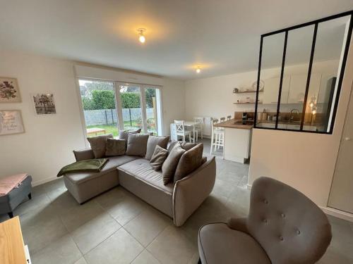 - un salon avec un canapé et des chaises dans l'établissement Freesia, Maison neuve avec jardin et garage, à Caen