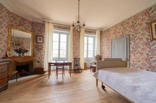 een slaapkamer met een bed en een tafel. bij Château Monvallon in Charentay