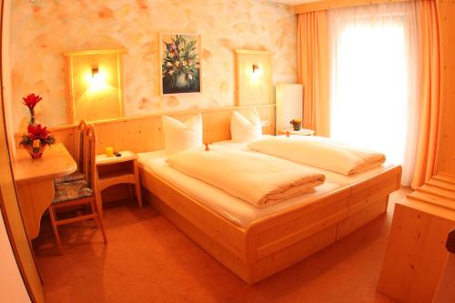 a bedroom with a bed and a desk and a window at das Christophorus in Söll
