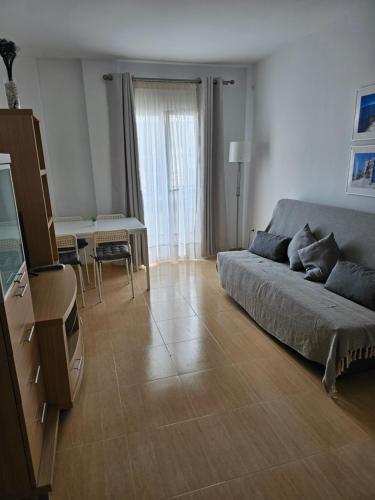 uma sala de estar com um sofá e uma mesa em Apartamento El Ingenio em Nerja