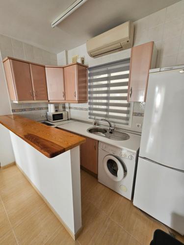 uma cozinha com um frigorífico branco e uma máquina de lavar roupa em Apartamento El Ingenio em Nerja