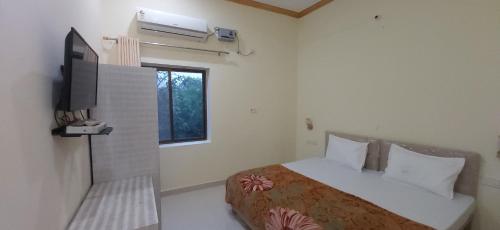 a bedroom with a bed and a television in it at Shivansh Palace HomeStay & Marriage Garden in Khajurāho