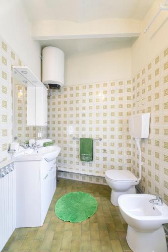 a bathroom with two toilets and a green rug at Locanda San Felice in San Felice del Benaco