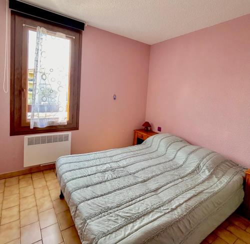 a bedroom with a bed and a window at Maisonnette 6 personnes à 500 m de la plage Parking 6GOEL18 in Le Barcarès