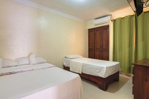 twee bedden in een kamer met groene gordijnen bij Family Vacation Rentals in La Viva