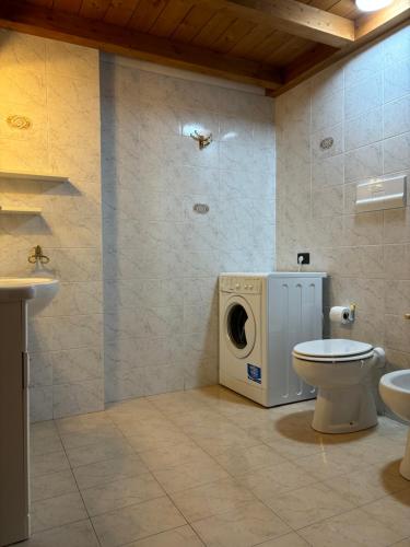 uma casa de banho com uma máquina de lavar roupa e um WC em Appartamento Morghen em Arco