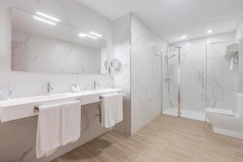 Un baño blanco con lavabo y ducha. en Soho Boutique Los Naranjos, en Málaga