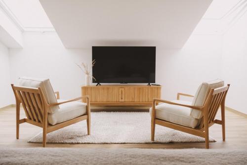 2 sillas frente a una TV en la sala de estar en Pure Flor de Esteva, en Vila do Bispo