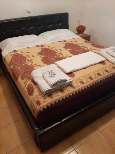 uma cama com duas toalhas brancas e dois computadores portáteis em Garufalia em Peshkëpia e Poshtme