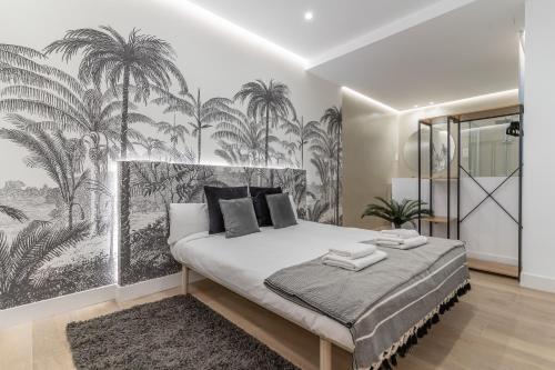 1 dormitorio con 1 cama grande con un mural de palmeras en Executive -2Bedrooms 2Bathrooms - Salamanca - MintyStay, en Madrid