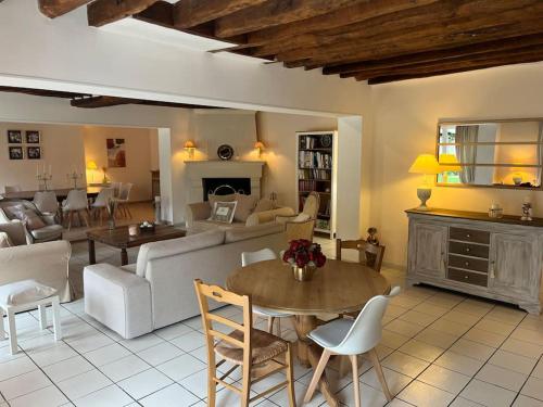 a living room with a couch and a table at Maison Hermitage Campagne Chic - Vexin in Aincourt