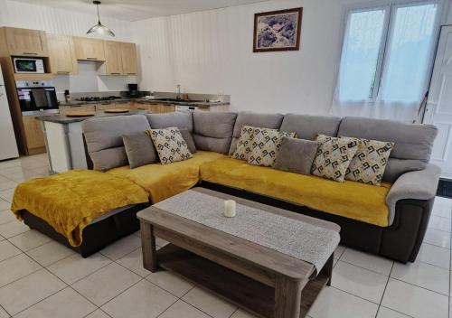 a living room with a couch and a table at Kaz'Bongo - Maison pour 6 en pleine nature in Capesterre-Belle-Eau