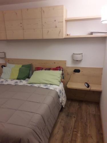 Habitación pequeña con cama y escritorio. en Casa De Sandre, en San Vito di Cadore