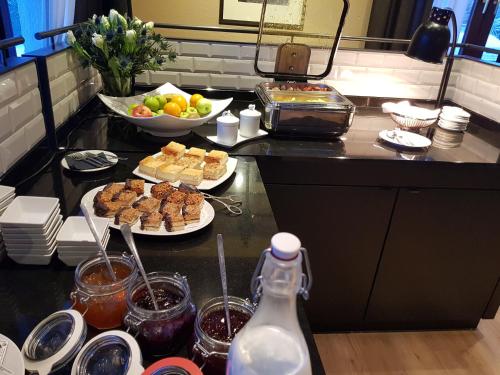 a kitchen counter with plates of food and a bowl of fruit at Hotel Stümpelstal in Marburg an der Lahn