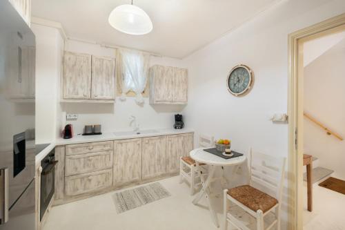 a kitchen with wooden cabinets and a small table at Villa Nausithoe 1 Paros in Logaras